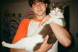 © Erin Brant/Stocksy - Teen boy holding pet cat indoors
