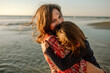 © Erin Brant/Stocksy - Mother embracing daughter on beach