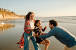 © Erin Brant/Stocksy - Dad reaching for laughing daughter at beach