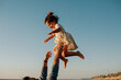 © Erin Brant/Stocksy - Dad tosses happy daughter high in the air