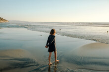 Girl Wading On Beach At Sunset