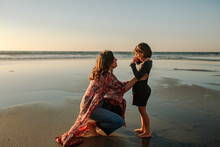 Mother Comforting Daughter On Beach