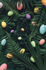 Wall Mural - Creative Easter nature background.Green tropical palm leaves with Easter eggs.Minimal spring abstract jungle or forest composition.Contemporary style Holiday Easter celebration greeting card or idea.