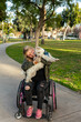 © Jayme Burrows/Stocksy - Woman in Wheelchair Hugs Dog