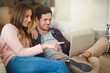 © Adene Sanchez/peopleimages.com - House hunting from the comfort of their couch. Shot of a happy young couple using a laptop together while relaxing on the sofa at home.