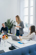 © Manu Padilla/Stocksy - Woman explaining project to colleagues in boardroom