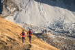 © plpictures by Paedii Luchs/Stocksy - Two trail runners jogging on a high altitude path.