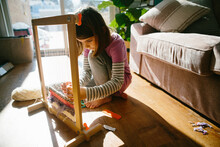 Young Girl Uses A Loom To Weave