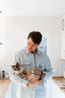 © Alba Vitta/Stocksy - Portrait of happy man hugging cat at home