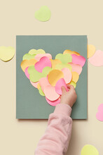 Kid Sticking Cutted Paper Hearts For Making Greeting Card