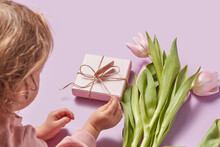 Female Child Preparing For Mom Gift Box And Tulips