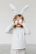 © Sergey Narevskih/Stocksy - Little kid in bunny ears with Easter eggs