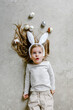 © Sergey Narevskih/Stocksy - Dreamy child lying on floor with Easter eggs