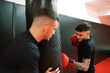 © Javier Díez/Stocksy - Male boxer exercising with trainer in gym