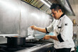 © Pedro Merino/Stocksy - Latin cook working in a restaurant kitchen