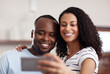 © Nikish H/peopleimages.com - First selfie of the weekend. Cropped shot of a young married couple taking a selfie in the kitchen at home.