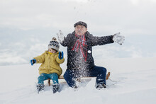 Grandpa And Grandson Having Fun On The Snow
