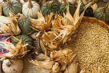 Variety Of Pumpkins And Corn Kernels In A Basket