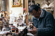 © Pedro Merino/Stocksy - Senior ceramic artist working in his workshop