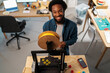 © Studio Marmellata/Stocksy - Joyful man operating on modern 3D printer and smiling