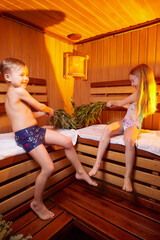 A girl and a boy in a Russian bath. Bathhouse in Russia for a family with a brother and sister. The concept of a healthy baby in the steam room