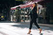 © Manu Padilla/Stocksy - Smiling woman in formal wear crossing road on crosswalk