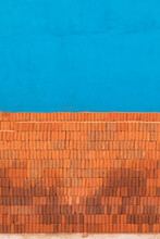Stacked Bricks In Front Of A Blue Wall 