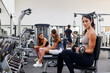 © Ivan Gener/Stocksy - Woman lifting weights in a busy gym
