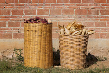 Two Large Baskets Full Of Corn In Front Of A Wall