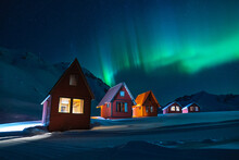 Northern Lights In Alaska's Mountains Over Red Cabins