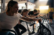 © Santi Nuñez/Stocksy - Motivated people exercising on cycling machine in gym