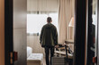 © Daniel Gonzalez/Stocksy - Man with suitcase entering hotel room during trip