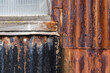 © Neil Perry/Stocksy - Rusty metal sheets and window