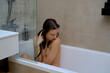 © Tatiana Timofeeva/Stocksy - naked woman while taking shower at home