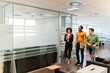 © David Prado/Stocksy - Cheerful multiethnic colleagues walking in office