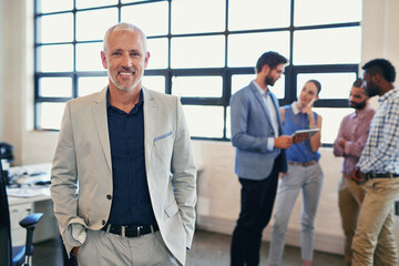 Aufkleber - Im happy to be part of this team. Portrait of a confident businessman posing in the office with his colleagues in the background.