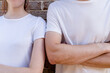 © Daria Nipot - Couple wearing mockup white t-shirts on brick wall background. Template fashion copy space