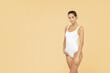 Young, fit and beautiful brunette woman in a white swimsuit posing in the studio. Health care, diet, sport and fitness.
