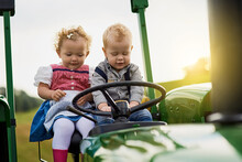 Who Needs A Tv With This Kind Of Entertainment. Shot Of Two Adorable Children Riding A Tractor Together On A Farm.