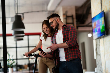 Wall Mural - Young businessman and businesswoman in the office. Two friends talking together.