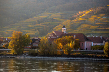 Wall Mural - autumn view of small austrian village on a river bank