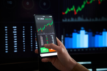 Closeup hand mobile - Person is checking Bitcoin price chart on digital exchange on smartphone, cryptocurrency future price action prediction.