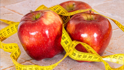 Wall Mural - close up of several red apples isolated on a table with a measuring tape