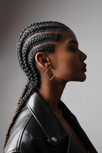 Vertical Portrait Of African Young Woman With Braids Posing On White Wall.