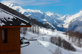 Fototapeta Niebo - Landscape of mountains with view on one of pistes in Alps, France , with  skiers