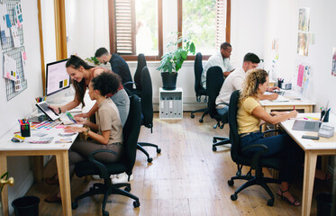 Wall Mural - A small office filled with big dreams. Shot of a group of young businesspeople working together modern office.
