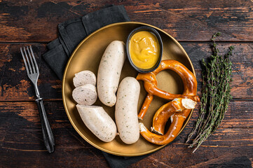 Wall Mural - Munich white sausage with pretzel and mustard. Wooden background. Top view