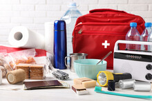 Disaster Supply Kit For Earthquake On White Wooden Table Near Brick Wall