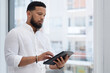 © Patrick Simba/peopleimages.com - Staying efficient while handling tasks. Shot of a young businessman using a digital tablet in an office.