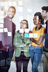 Canvas Print - He might be onto something. Cropped shot of a group of businesspeople working on a glass wall the office.